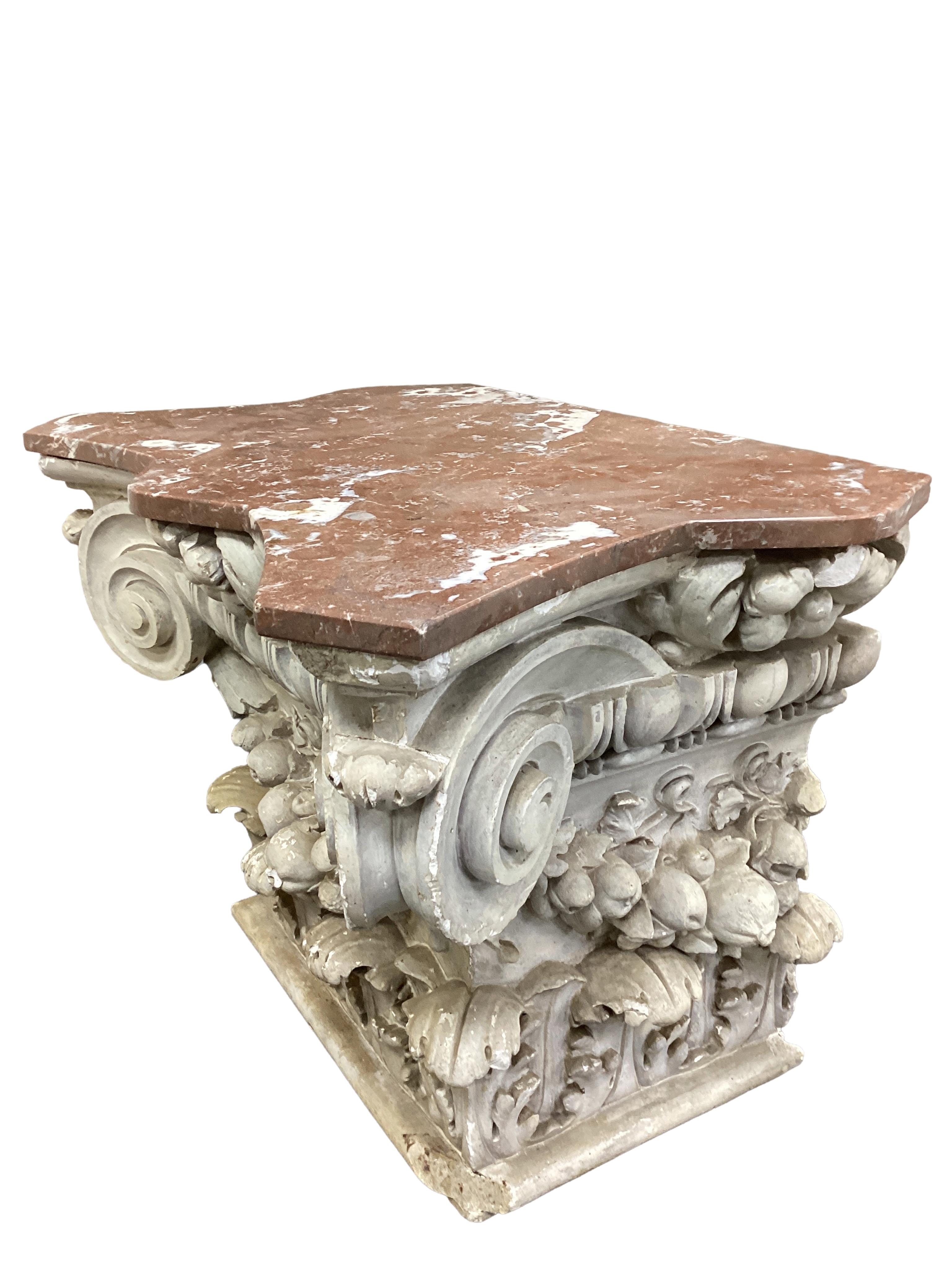 A marble topped white painted composition Ionic capital